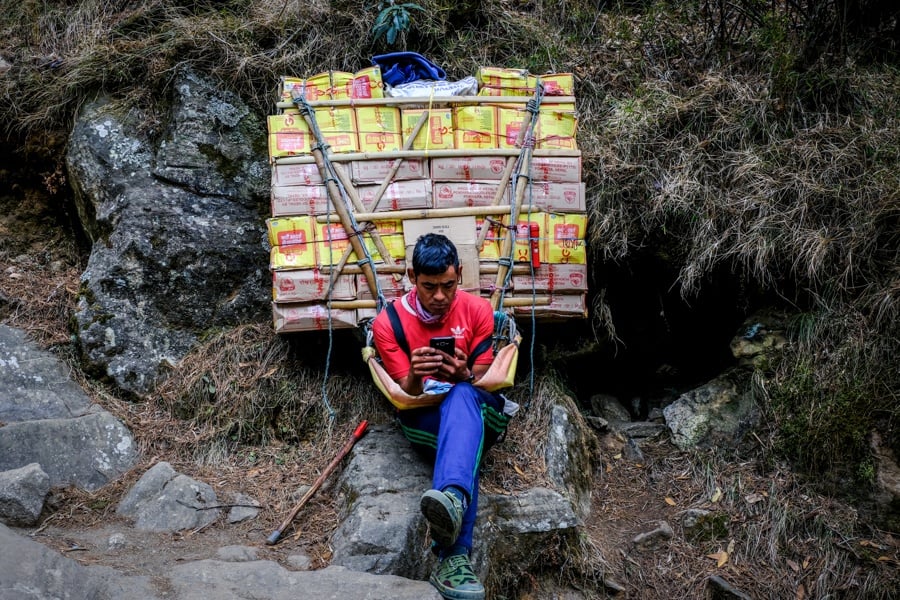 Porter with a huge pack on the EBC trek in Nepal